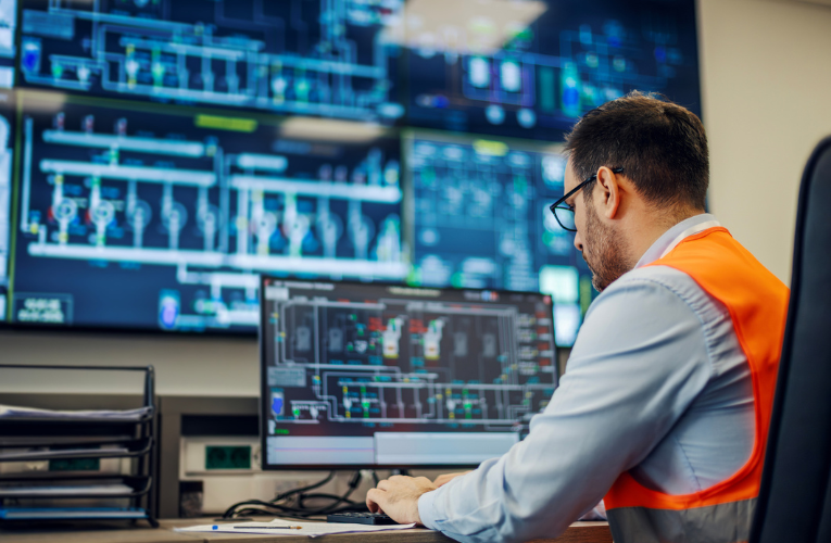 A utility operations engineer monitors real-time network performance across control room dashboards, showcasing how data-driven visibility supports smarter, more resilient grid operations.